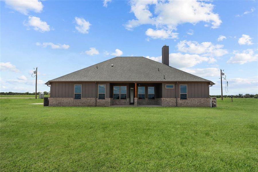 Rear view of property featuring a lawn