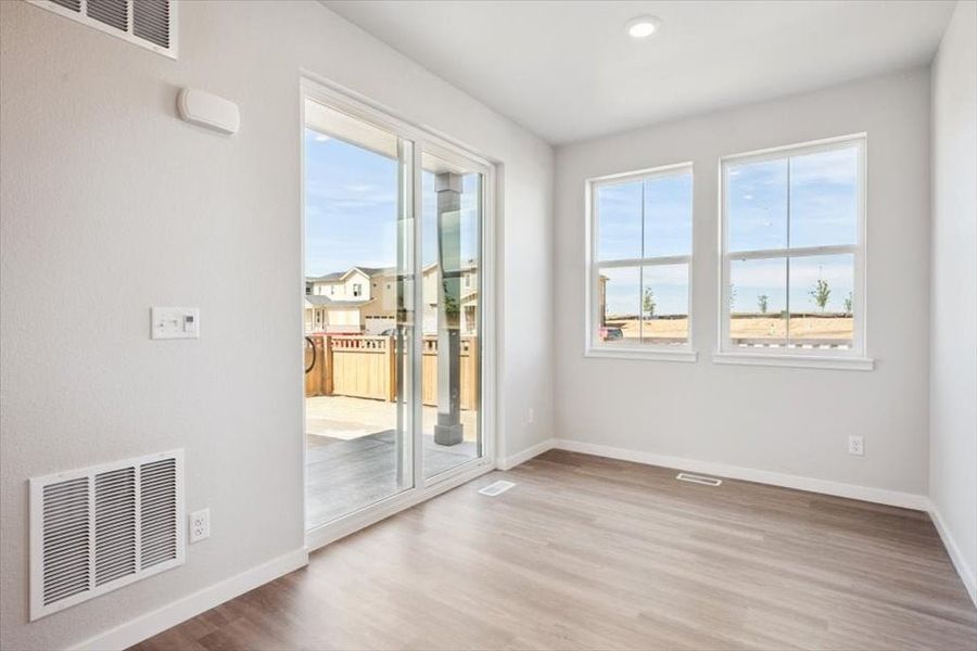 A room with a wood floor and windows.