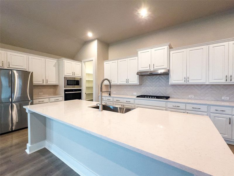 Kitchen with stainless steel appliances, white cabinets, decorative backsplash, light stone countertops, and dark wood-type flooring Kitchen with stainless steel appliances, white cabinets, decorative backsplash, light stone countertops, and dark wood-type flooring