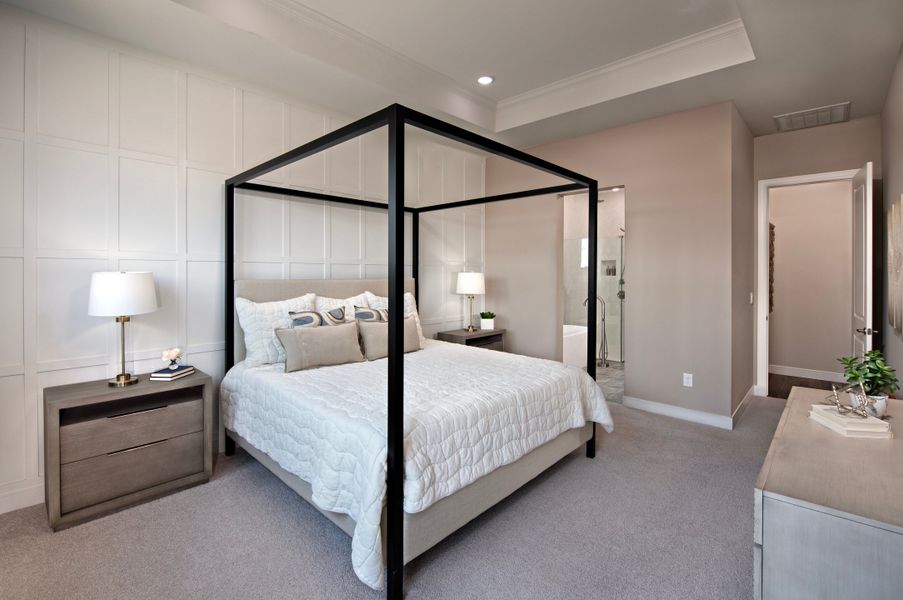 Primary suite with coffered ceiling and decorative feature wall