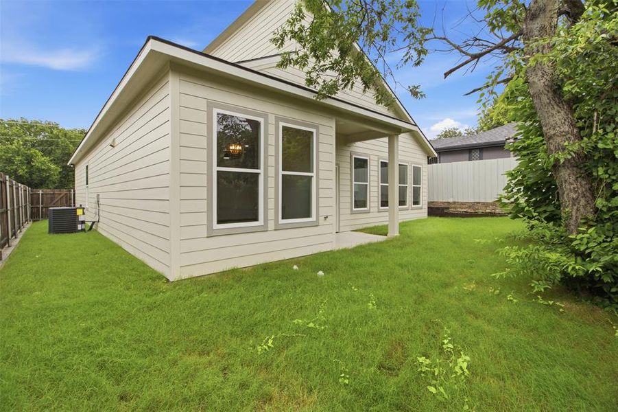 Rear exterior featuring light-colored horizontal siding and a covered patio area
