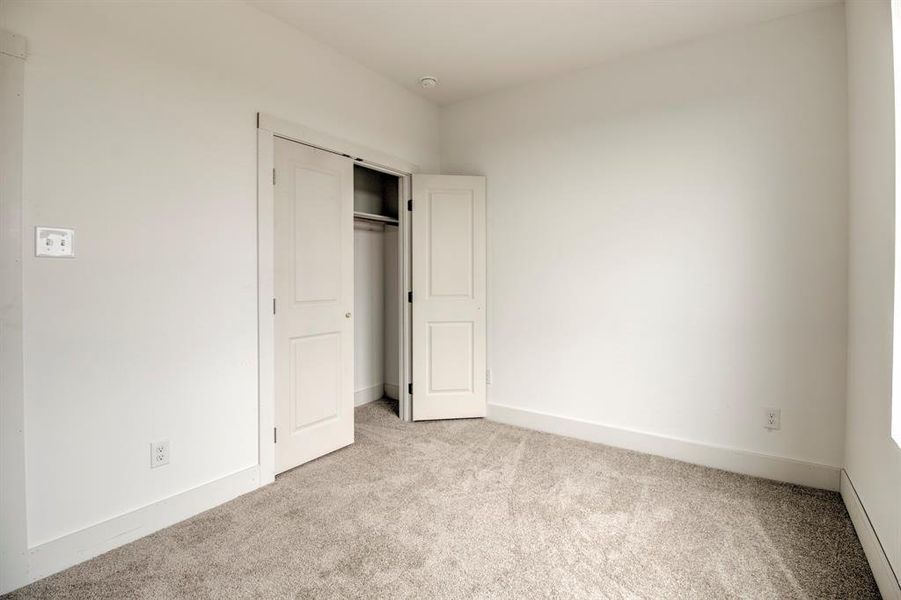 Unfurnished bedroom with carpet flooring and a closet Unfurnished bedroom with carpet flooring and a closet