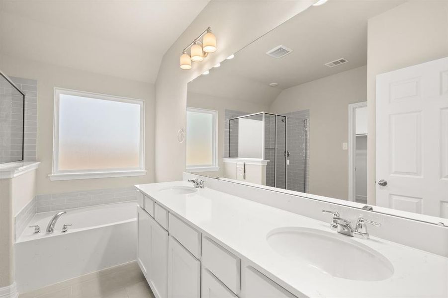 The en-suite bathroom offers a spa-like atmosphere with its elegant design, high end finishes, and tasteful lighting, creating a retreat within your own home.