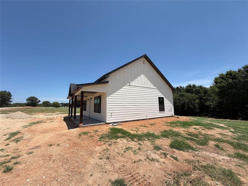 Newly constructed residence featuring white horizontal siding and a dark gabled roof