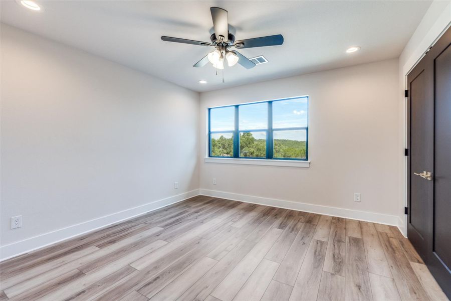 Unfurnished bedroom with a ceiling fan, light wood-style flooring, and recessed lighting