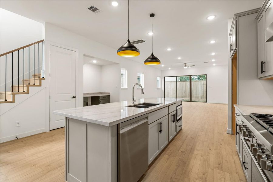 Seamless entertainer's layout — kitchen view looking directly toward the glass patio doors and light-filled main living hall.