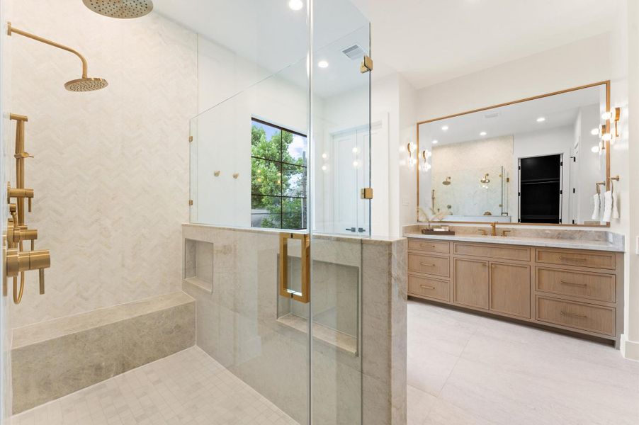 Primary bathroom boasts marble shower wall and a quartzite waterfall bench. Primary bathroom boasts marble shower wall and a quartzite waterfall bench.
