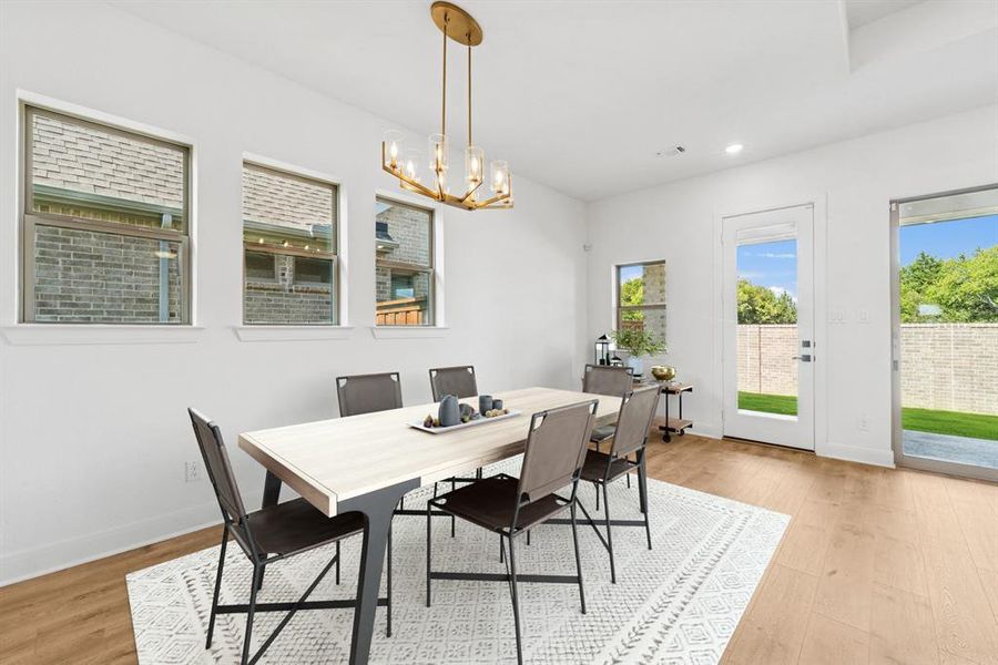 Dining area with light wood finished floors and hanging lights Dining area with light wood finished floors and hanging lights