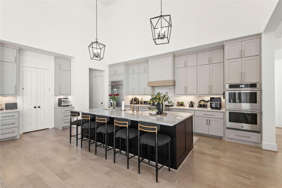 Double tier cabinets, coffee station and walk in pantry. Hallway off of kitchen has garage access for a 2 car and separate 1 car with drop zone/jacket center.