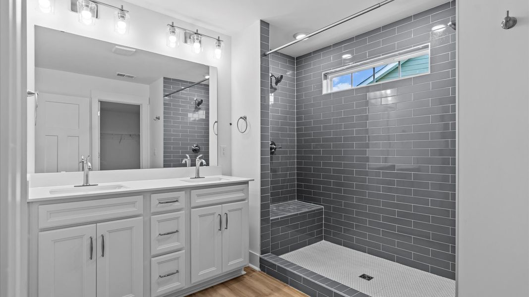 Highly functional and elegant en-suite with dual vanities, tiled walk-in shower, and refined finishes