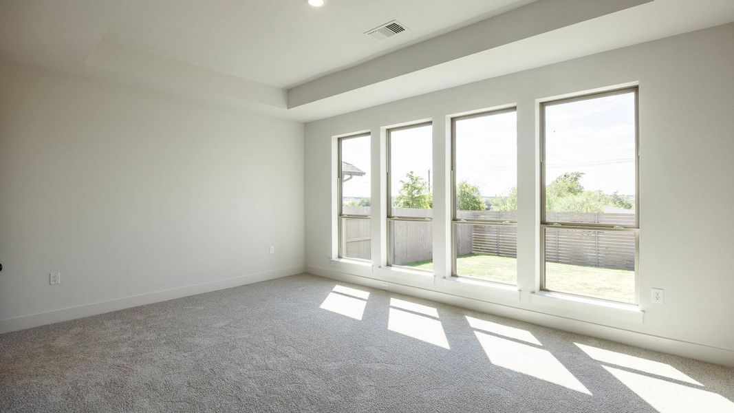 Carpeted spare room featuring a raised ceiling and recessed lighting Carpeted spare room featuring a raised ceiling and recessed lighting
