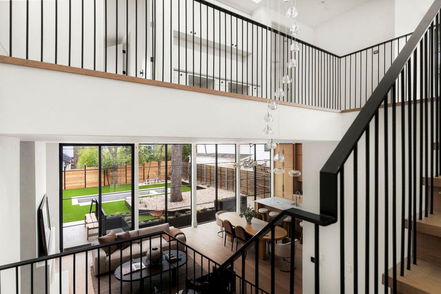 Staircase with wood finished floors, a high ceiling, and hanging lights