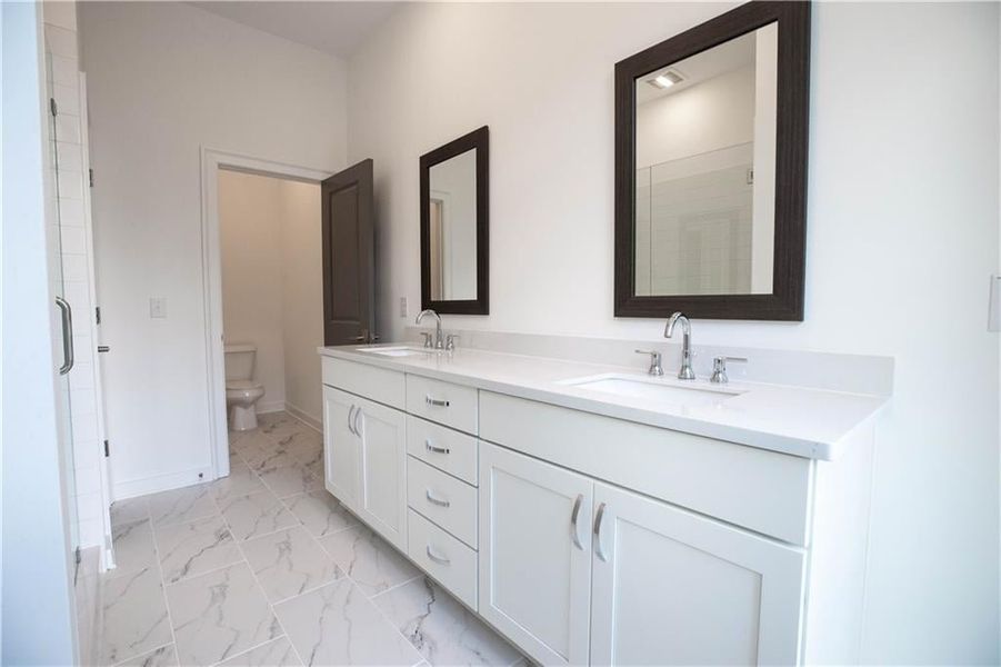 Primary Bathroom features quartz countertops, dual vanity, framed mirrors and upgraded tile *Home is Under Construction. Photos shown are from other TPG Communities to display how the home will live*