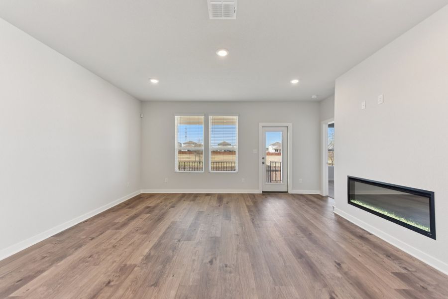 A room with a wood floor and a wood floor with a fireplace. A room with a wood floor and a wood floor with a fireplace.