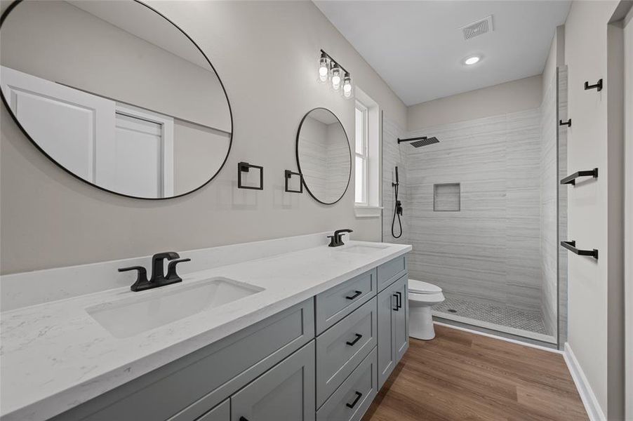 Primary bath has dual vanities as well as large walk-in shower.