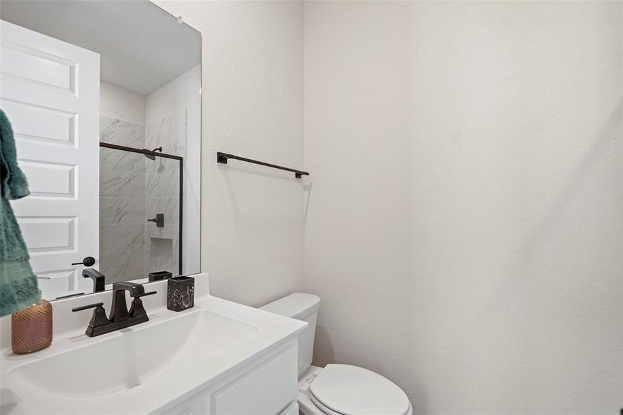 The first floor guest bathroom includes a spacious shower.