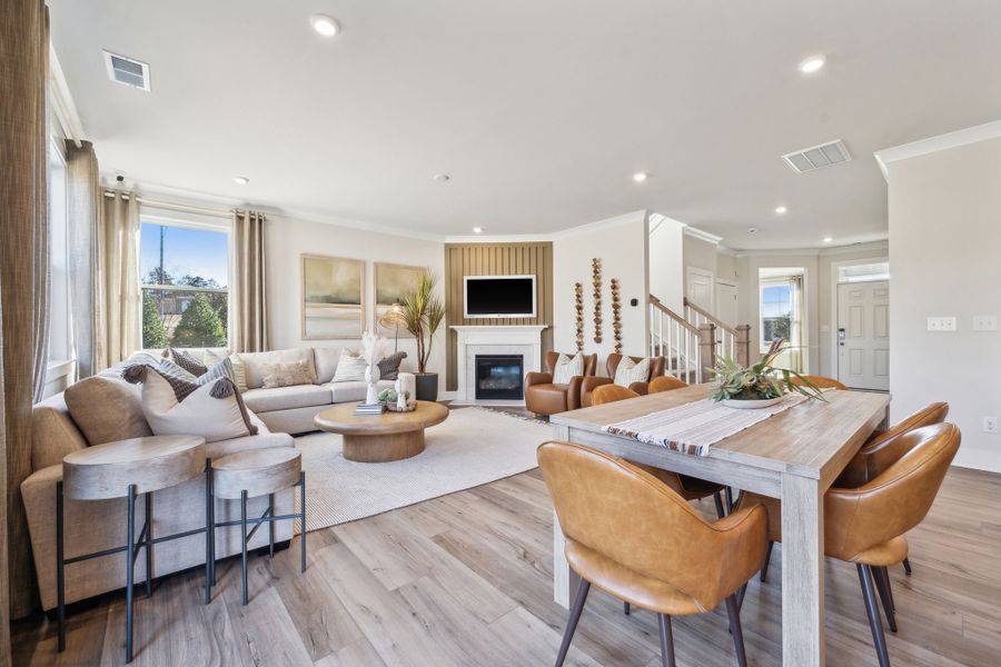 A large living room with a large dining table and a fireplace. A large living room with a large dining table and a fireplace.