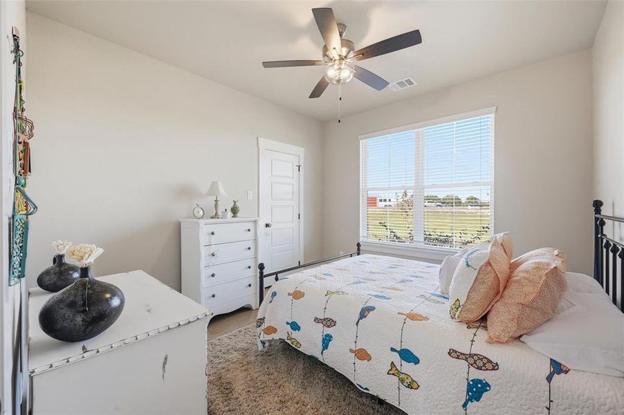 Carpeted bedroom featuring ceiling fan Carpeted bedroom featuring ceiling fan