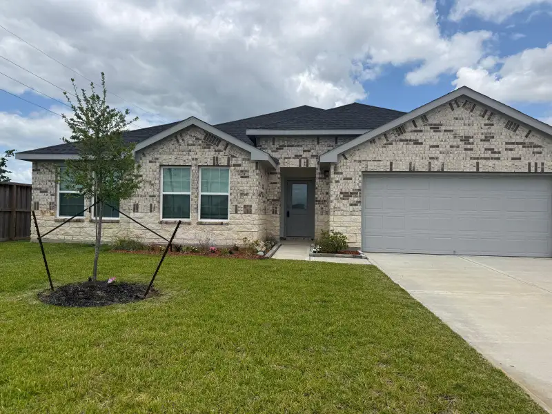 Front exterior of a new home in Evergreen, Rosenberg, TX, highlighting curb appeal (Image 1). Front exterior of a new home in Evergreen, Rosenberg, TX, highlighting curb appeal (Image 1).
