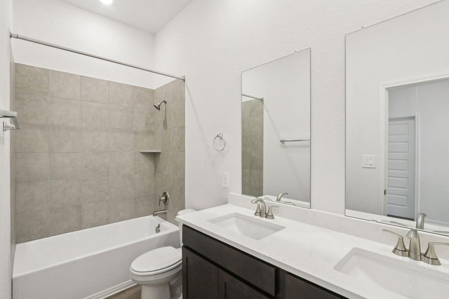 Full bathroom featuring shower / tub combination and double vanity Full bathroom featuring shower / tub combination and double vanity