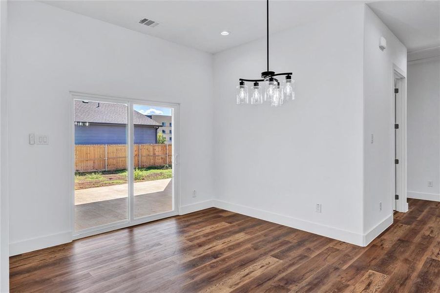 Unfurnished dining area with dark wood-style floors and recessed lighting