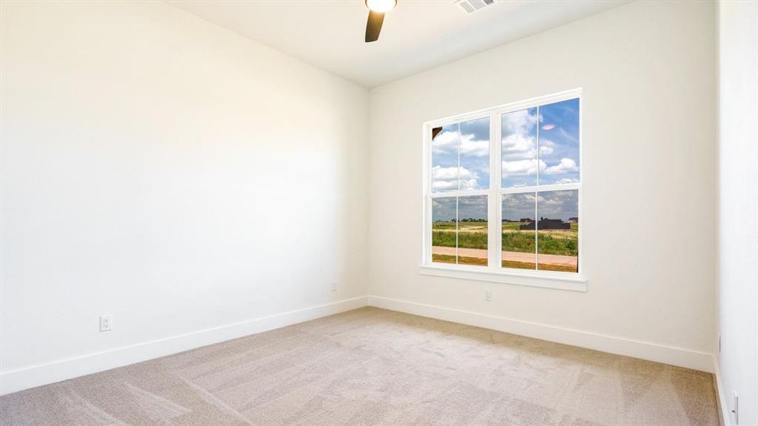 Carpeted empty room with ceiling fan