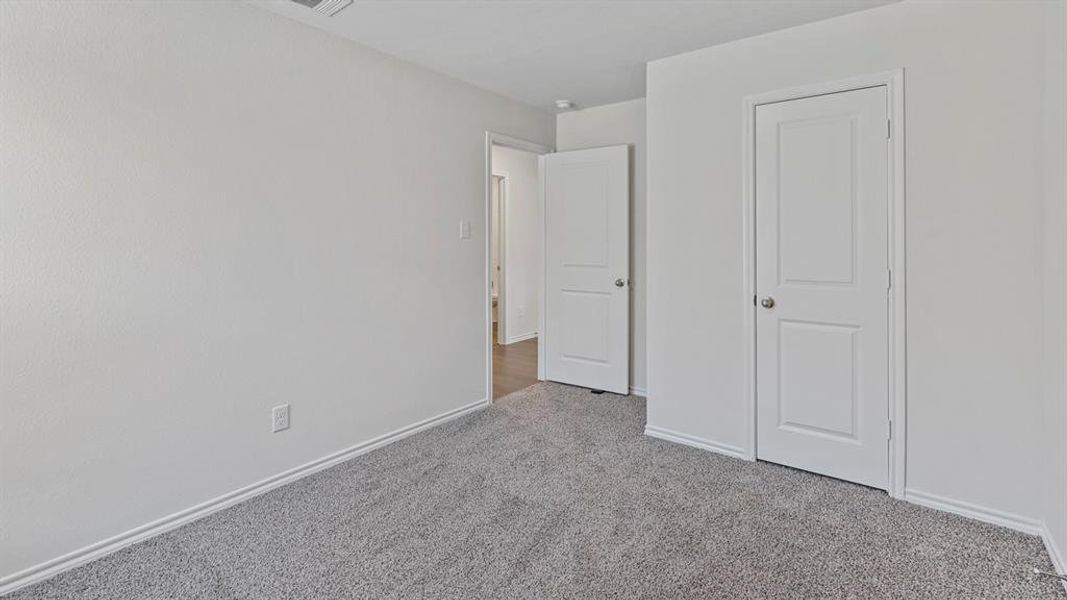 Unfurnished bedroom featuring light carpet and baseboards Unfurnished bedroom featuring light carpet and baseboards