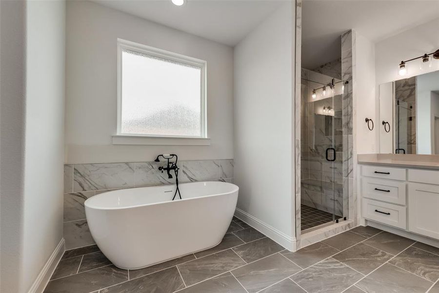 Bathroom featuring tile flooring, independent shower and bath, and vanity