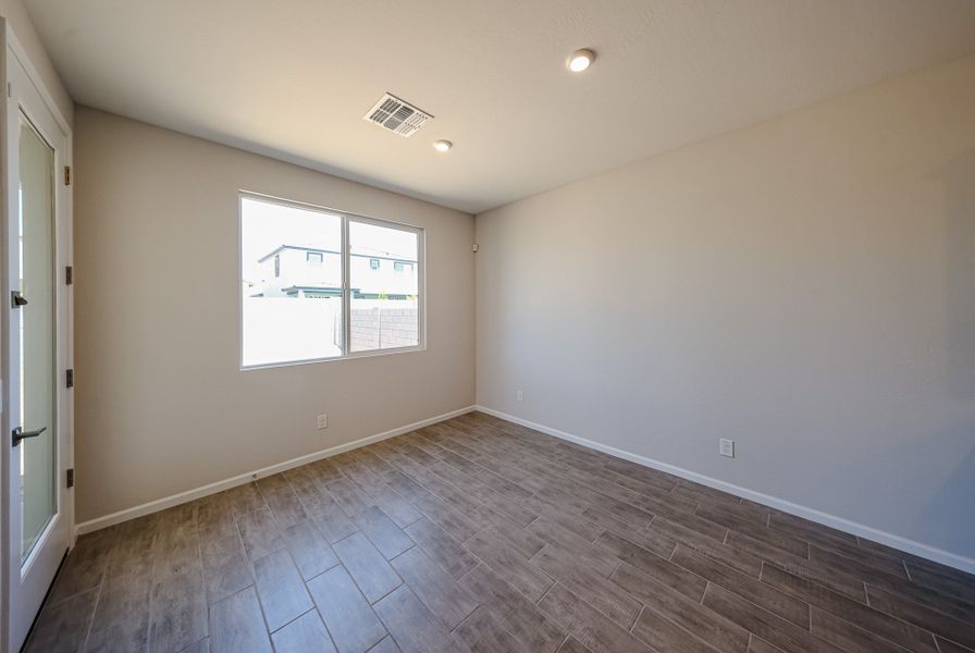A room with a wood floor and a window with blinds. A room with a wood floor and a window with blinds.