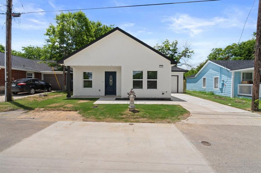 View of front facade featuring brick siding, a front yard, and concrete driveway View of front facade featuring brick siding, a front yard, and concrete driveway