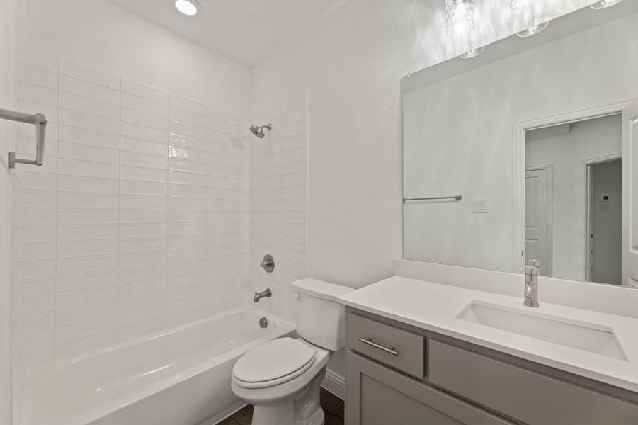 Full bathroom featuring toilet, tiled shower / bath, and vanity