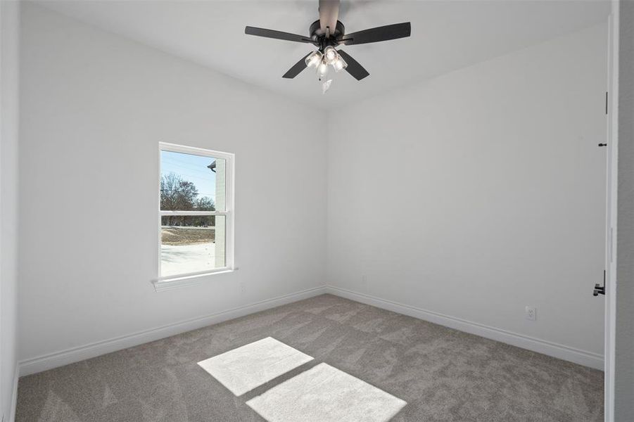 Carpeted empty room with ceiling fan