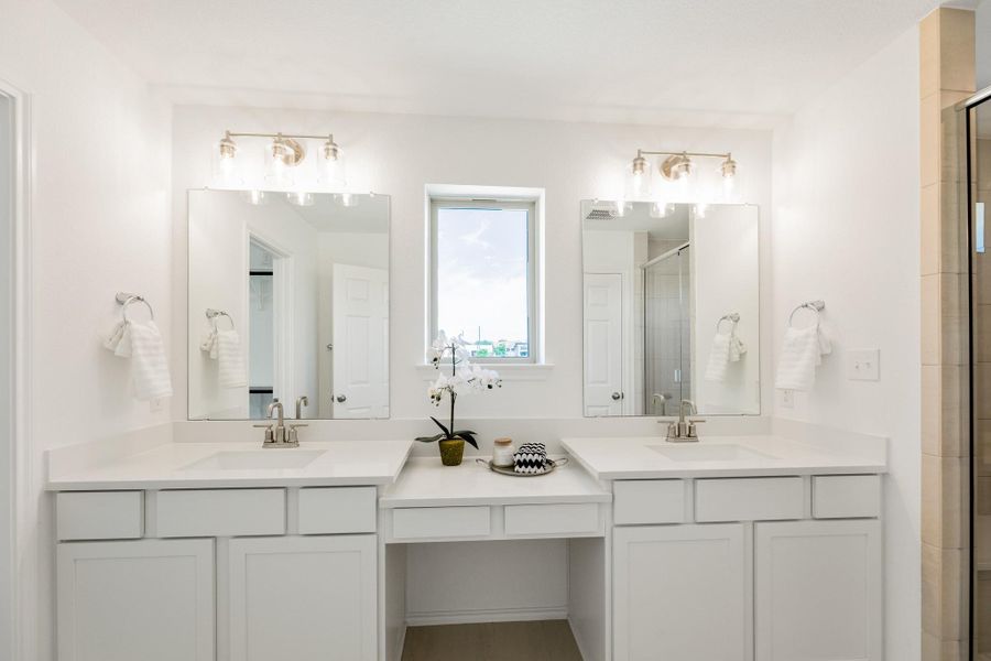 Full bathroom featuring double vanity and a stall shower