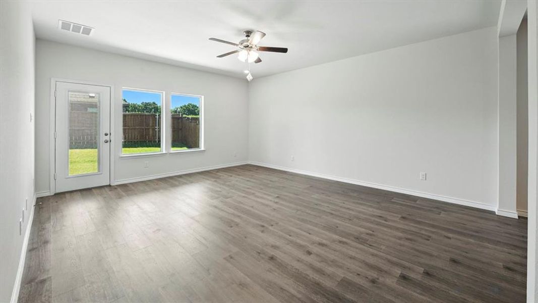 Empty room featuring dark wood-style flooring and ceiling fan Empty room featuring dark wood-style flooring and ceiling fan