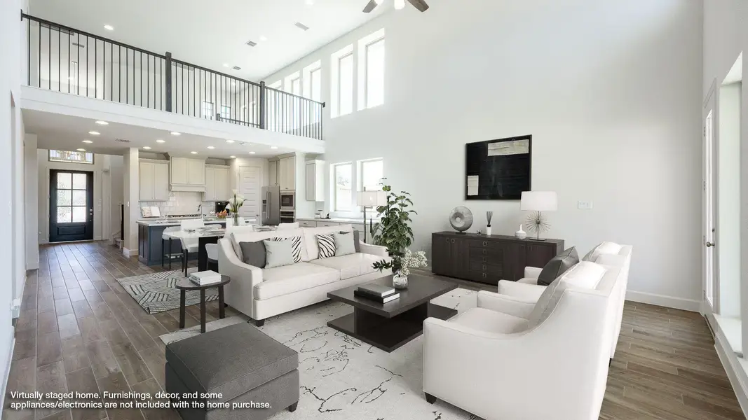 Living area with plenty of natural light, light wood-type flooring, recessed lighting, and a towering ceiling Living area with plenty of natural light, light wood-type flooring, recessed lighting, and a towering ceiling