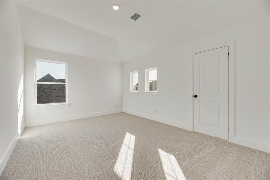Empty room with carpet flooring, recessed lighting, and vaulted ceiling