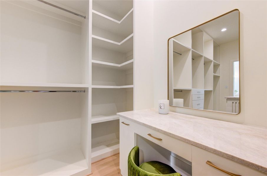 A boutique-inspired dressing area adds a touch of everyday luxury, featuring a dedicated vanity with stone countertops, custom cabinetry, and designer finishes. Thoughtfully integrated into the expansive walk-in closet, this elegant space creates the perfect setting for morning routines, wardrobe styling, and personal organization.
