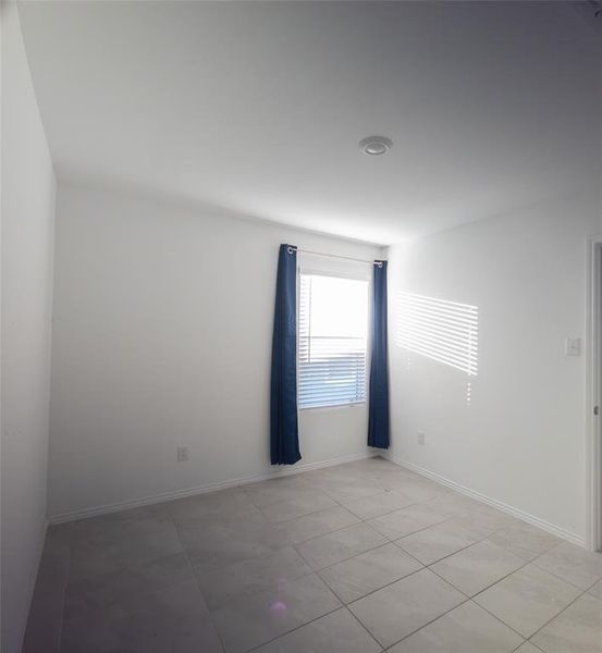 Empty room featuring light tile patterned floors