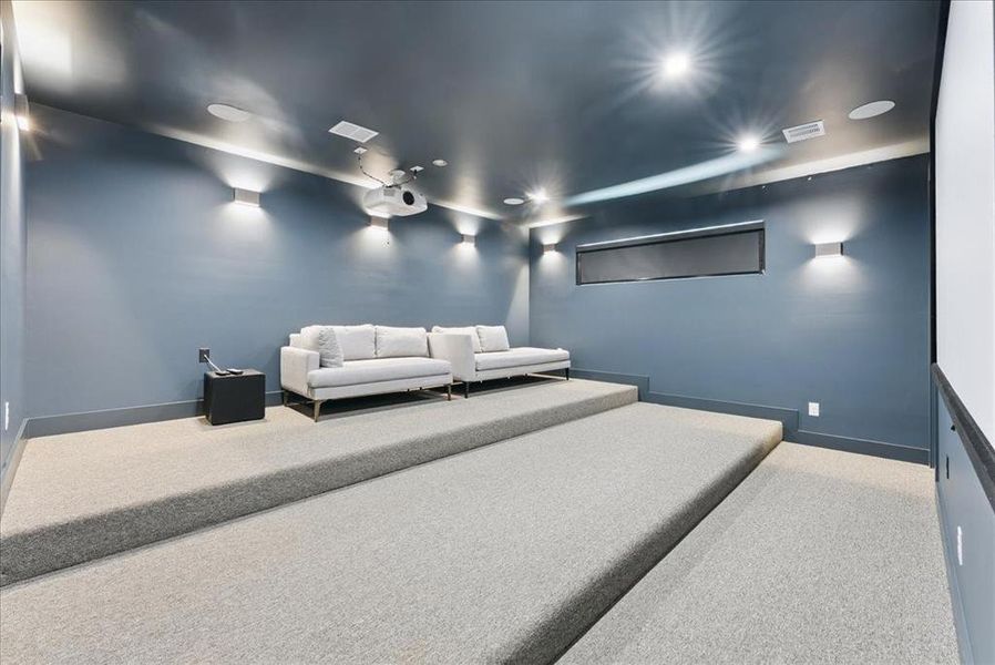 Cinema room featuring baseboards and light colored carpet