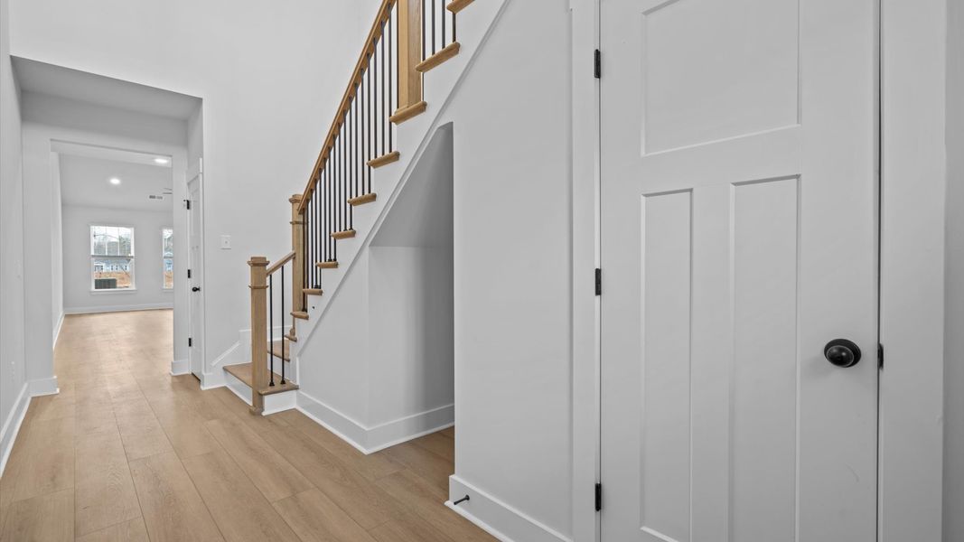 Highly functional foyer with hardwood flooring that flows seamlessly into living spaces