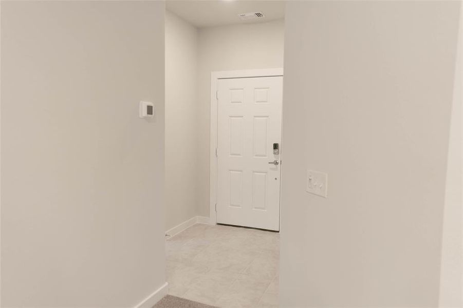 Hall featuring light tile patterned floors