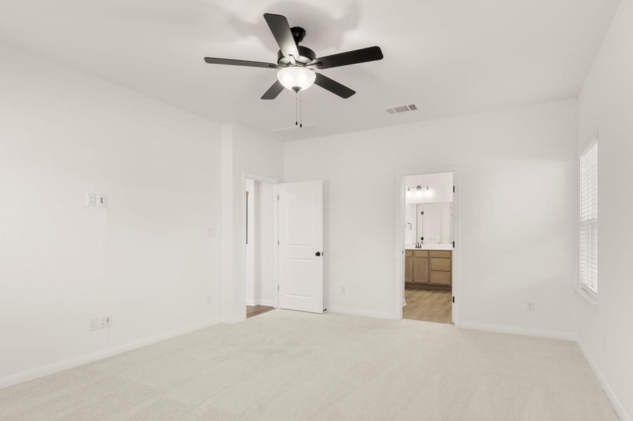 Unfurnished bedroom with light colored carpet, ceiling fan, and ensuite bathroom Unfurnished bedroom with light colored carpet, ceiling fan, and ensuite bathroom
