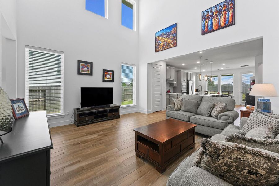 The living room features soaring ceilings and large windows that fill the space with light. This home is built with energy-efficient features, including a tankless water heater and an Energy Star rated 15.2 SEER2 HVAC system, ensuring comfort and savings.