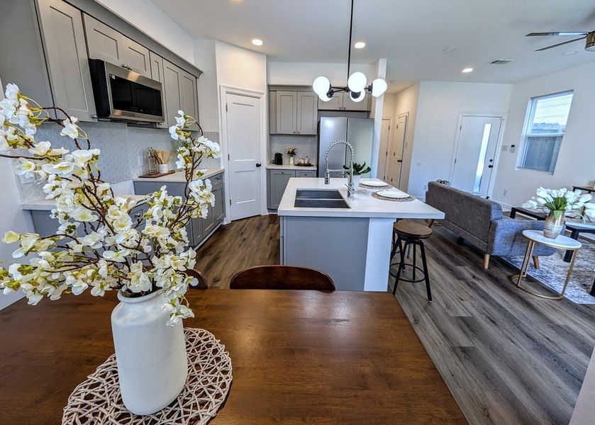 Centered by a functional island with quartzite counters, this kitchen includes soft-closing cabinets and drawers for a premium tactile experience. The walk-in pantry and stainless steel appliances support both daily meal prep and home-based hosting.