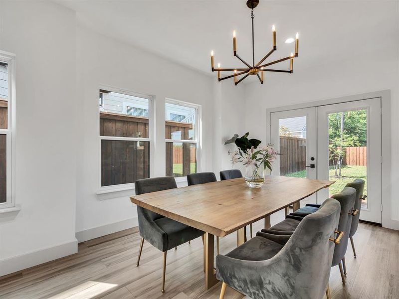 Dining room featuring a chandelier, plenty of natural light, and light wood finished floors Dining room featuring a chandelier, plenty of natural light, and light wood finished floors