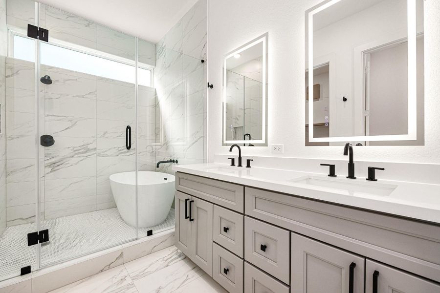 Indulge in spa-like luxury with this breathtaking primary bathroom, featuring an elegant double vanity with sleek quartz countertops, modern black fixtures, and illuminated mirrors. The stunning wet room design showcases a freestanding soaking tub and an oversized glass-enclosed shower adorned with marble-inspired tile. Indulge in spa-like luxury with this breathtaking primary bathroom, featuring an elegant double vanity with sleek quartz countertops, modern black fixtures, and illuminated mirrors. The stunning wet room design showcases a freestanding soaking tub and an oversized glass-enclosed shower adorned with marble-inspired tile.