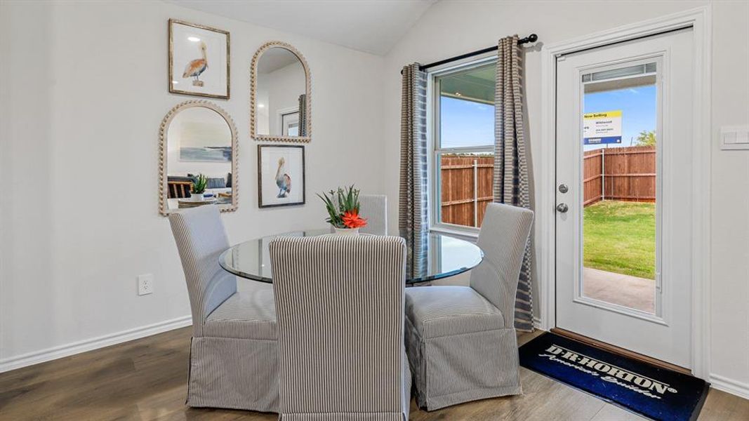Dining space with lofted ceiling and wood finished floors Dining space with lofted ceiling and wood finished floors