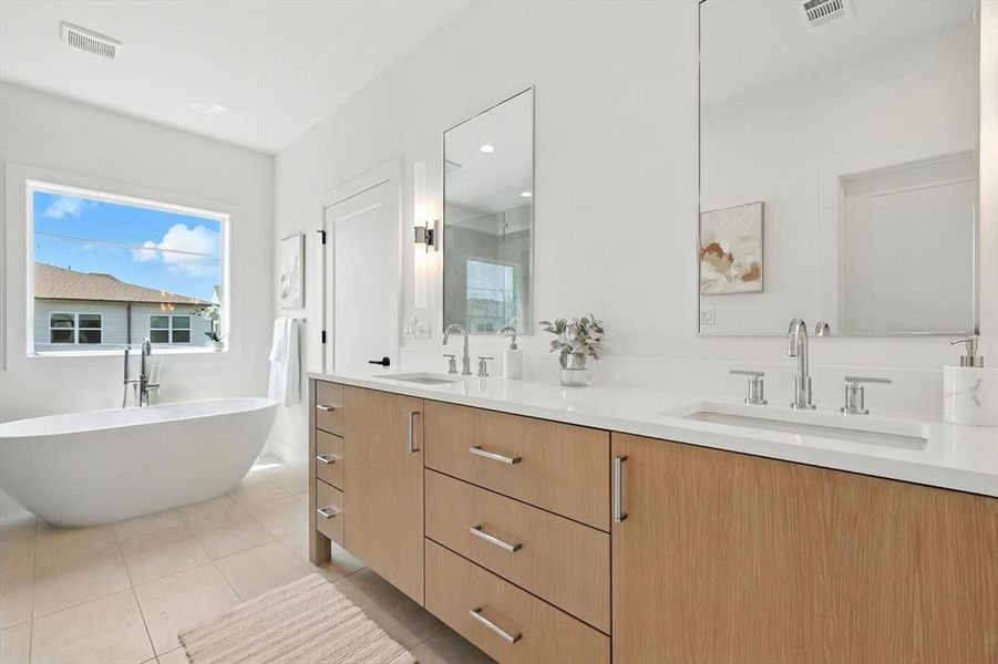 Bathroom featuring double vanity, a shower stall, a soaking tub, light tile patterned floors, and recessed lighting Bathroom featuring double vanity, a shower stall, a soaking tub, light tile patterned floors, and recessed lighting