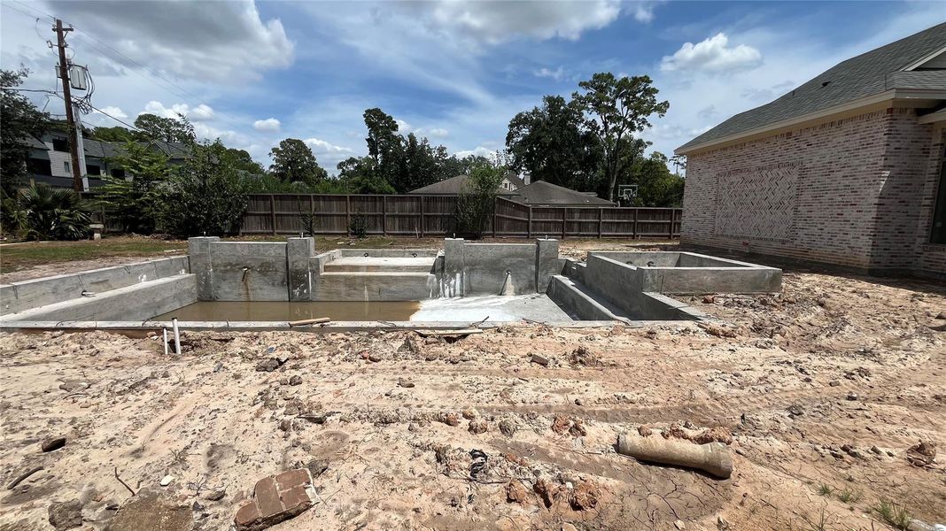 A progress photo in August 2025 showing the pool installation in the backyard. There will be a hot tub, sun tanning platform, and gas powered fire braziers.