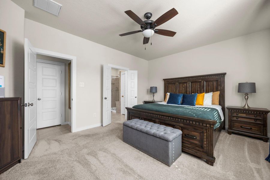 The large windows that fill the primary bedroom with natural light, creating a bright and airy atmosphere.